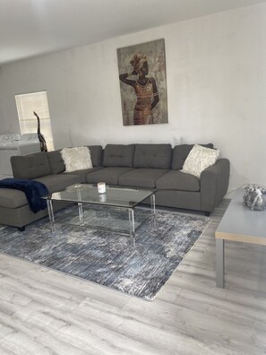 Relax in this stylish living room with a large sofa, coffee table, and shag rug.