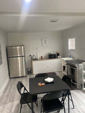 Compact kitchen with a dining table, sink, and oven.