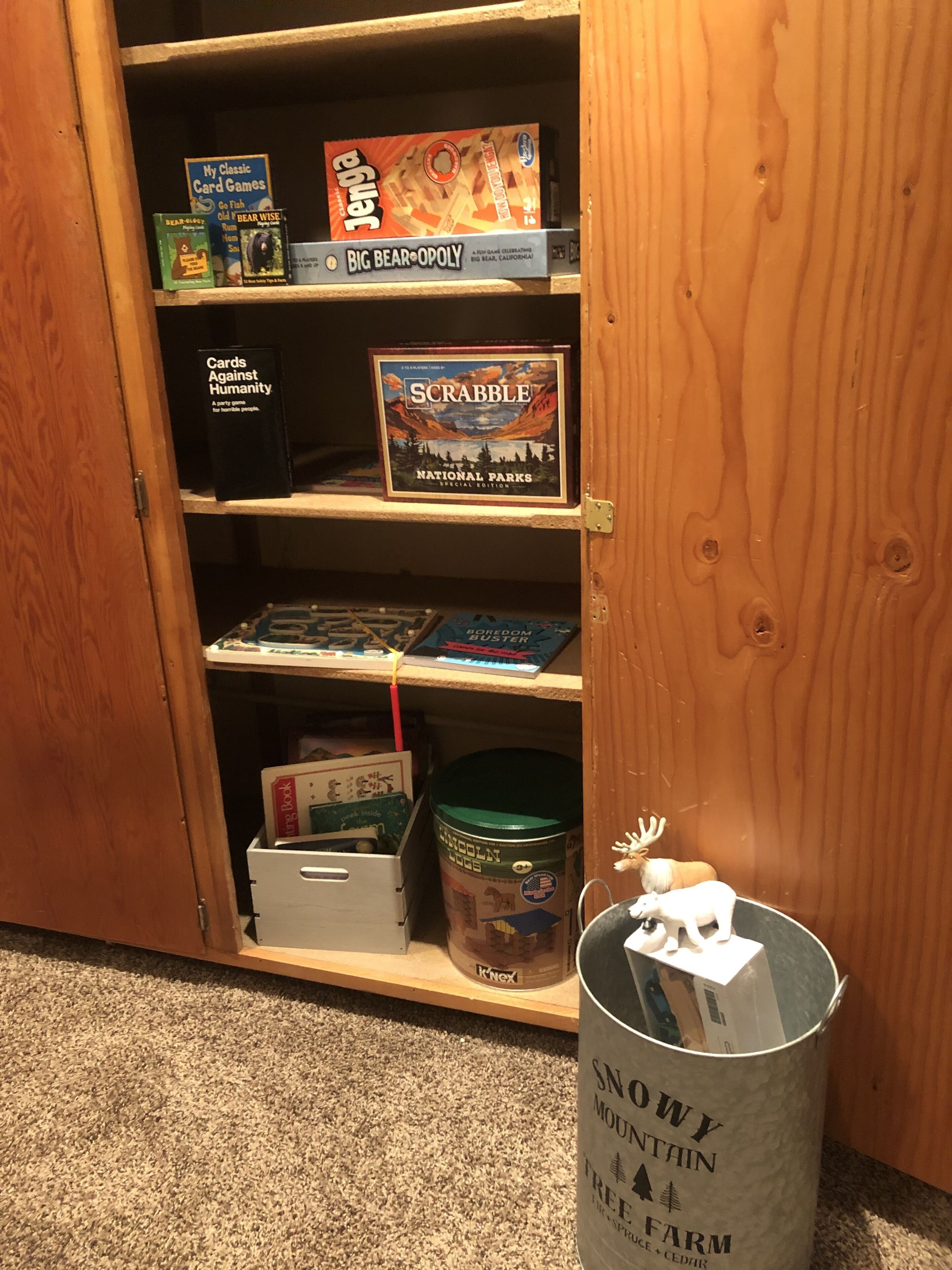 Uno scaffale con diversi giochi da tavolo, tra cui Scrabble e Go Fish.