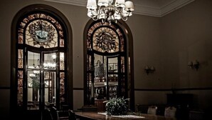 A room with a chandelier, stained glass windows, and a bar area. - Curia Palace Hotel Spa and Golf (Anadia)