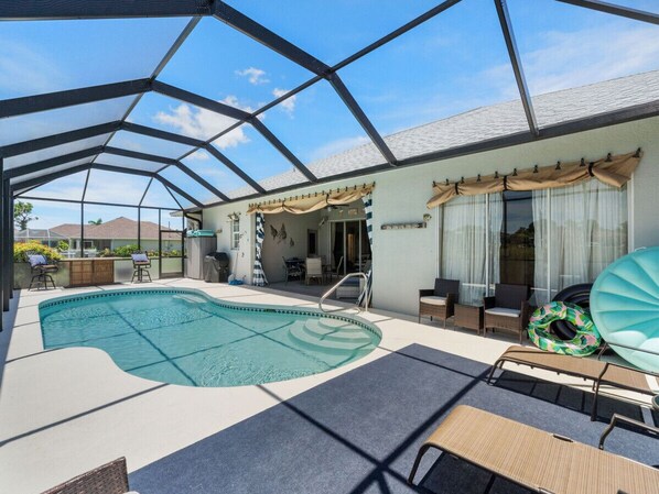 A covered swimming pool with a glass ceiling, lounge chairs, and a patio area. - Florida Pearl near Englewood & Boca Grande Beaches (Rotonda West)