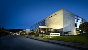 Un edificio moderno con un amplio frente de vidrio y un cartel que dice