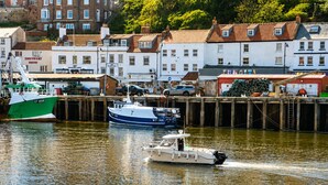 A harbor with boats, a dock, and buildings in the background. - Whitby Sea View Cottage Harbour Views Quiet Cragg (Whitby)