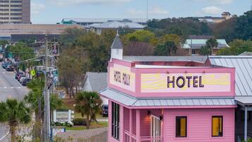 A pink building with a sign that reads 'HOTEL FOLLY.'