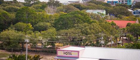 Un edificio rosa con un cartel que dice 'HOTEL' y vista al océano de fondo.