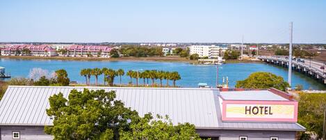 A hotel with a view of a body of water and a bridge in the background.