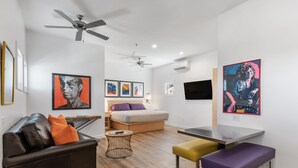 Een moderne woonkamer met een bank, een salontafel, een eettafel en een bed.