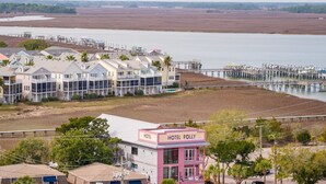 Een kusthotel met meerdere gebouwen, een steiger en een strand op de achtergrond.