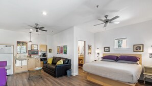 Une chambre moderne comprenant un lit, un canapé, un coin repas et une cuisine.