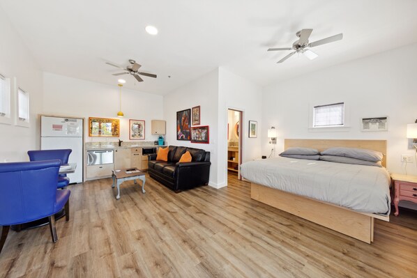 Un dormitorio moderno con cama, escritorio, silla y sofá.