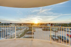 Enjoy a view of the surrounding area from this balcony with a parking lot and distant buildings.
