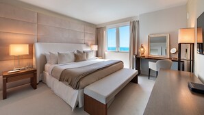 A modern hotel room with a large bed, bedside tables, a desk, and a view of the ocean. - Luxurious 1/1 Ocean View Condo 1416 - Located at 1 Hotel & Homes South Beach (Miami Beach)