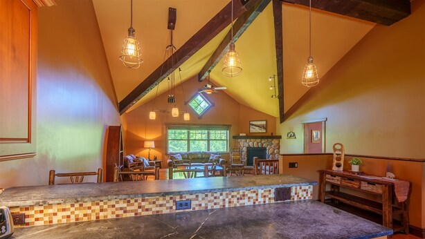 Una cocina amplia con una isla grande, una chimenea de piedra y un comedor con mobiliario de madera.