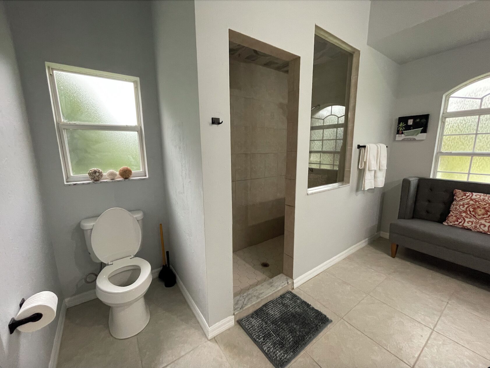 Un baño con inodoro, ducha y ventana.