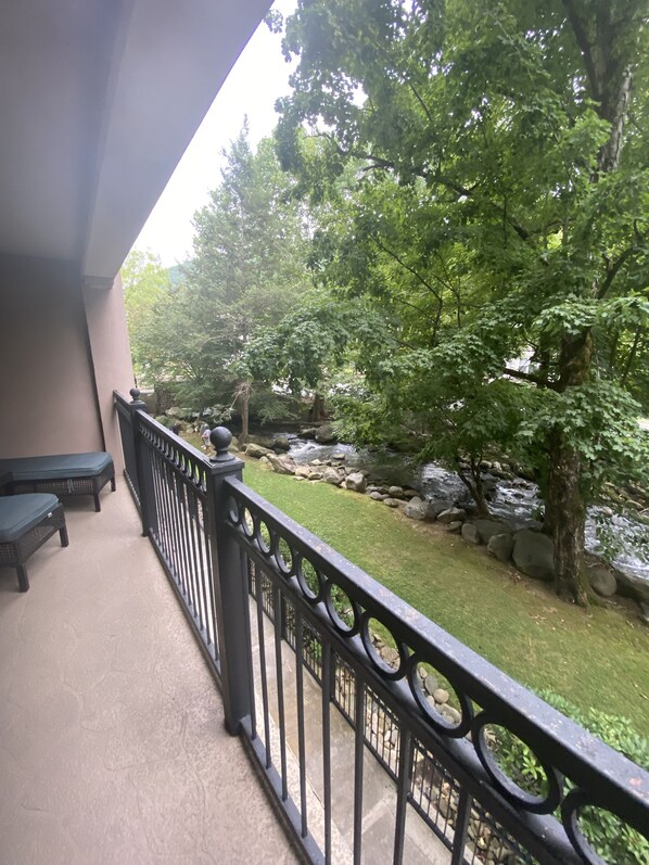 A balcony with a view of a garden and a stream. - CREEKSIDE VIBES 2BR/2BA 1ST FLOOR, WALK TO GATLINBURG, -AUGUST SPECIAL! BOOK NOW (Gatlinburg)