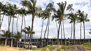 A beachfront hotel with multiple floors, palm trees, and a sandy beach. - Exceptionally Remodeled Oceanfront, Sunsets,  A/C, King bed Hale Kai O Kihei (Kihei)
