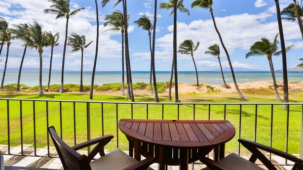 A balcony with a view of palm trees and the ocean. - Exceptionally Remodeled Oceanfront, Sunsets,  A/C, King bed Hale Kai O Kihei (Kihei)