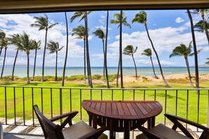 Un balcone con vista su palme e sull'oceano.