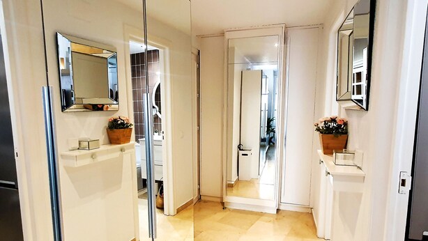 A hallway with mirrored walls, a tiled floor, and a door leading to a bathroom. - Wonderful Studio in Marbella Centre on the Second Line Beach (Marbella)