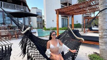 Na praia, espreguiçadeiras, guarda-sóis, toalhas de praia