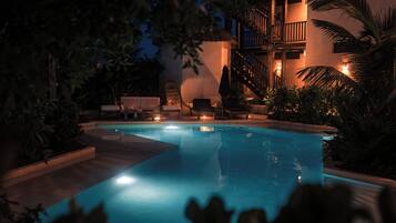 A swimming pool with lounge chairs and a staircase leading to an upper level.