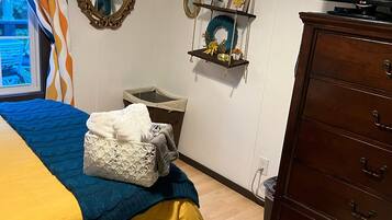 Une chambre à coucher comprenant un lit, une commode, un téléviseur et des étagères décoratives.