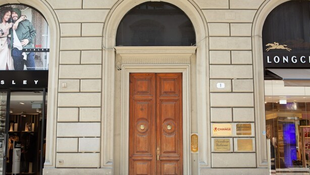 A building facade with a central wooden double door, a 'SISLEY' sign above the door, and a 'LONGC' sign to the right. - Florence Luxury Apartment al Duomo by Mmega (Firenze)