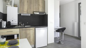 Una cucina moderna con mobili in legno, lavastoviglie integrata, lavello e uno sgabello da bar.