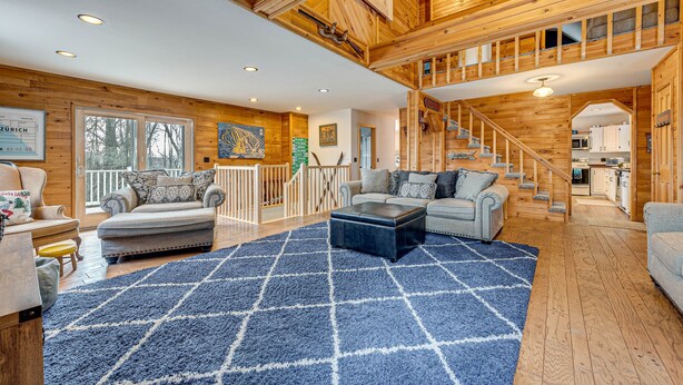 A spacious living area with a high ceiling, wooden beams, and a staircase leading to an upper level. - 2 Mi to Elk Mountain: Poconos Escape on 11 Acres! (Union Dale)
