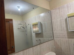 Een bad/douchecombinatie, handdoeken, zeep, shampoo