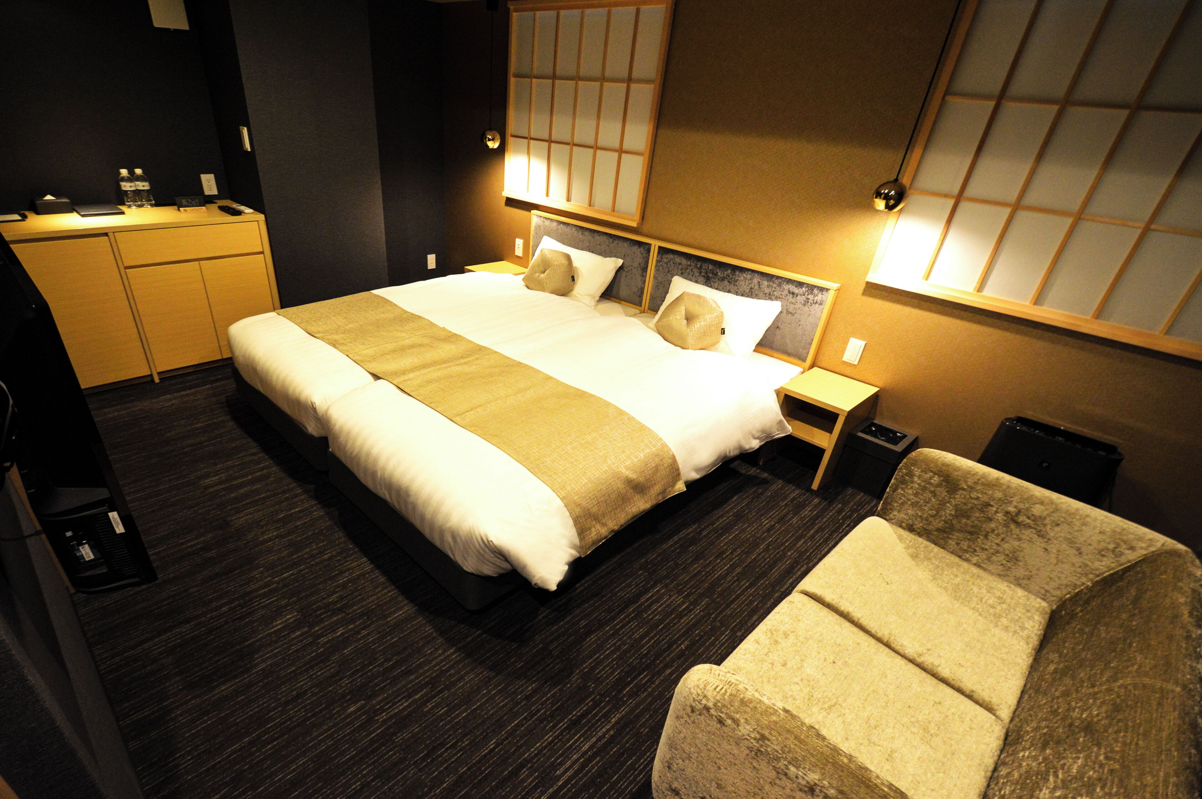 Una habitación de hotel con cama, mesitas de noche, un escritorio y una silla.