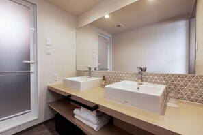Een moderne badkamer met twee wasbakken, een spiegel en een handdoekhouder.