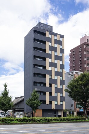 Een modern meerlaags gebouw met een gefacadeerd raster, grote ramen en een plat dak.