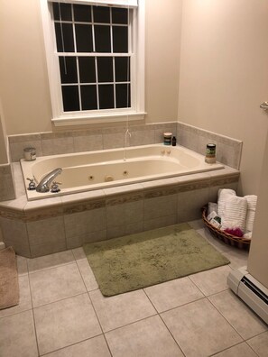 Bañera con ducha, bañera de hidromasaje, toallas, jabón
