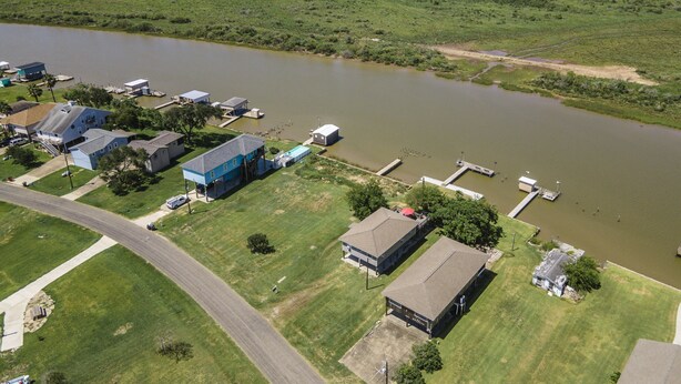 An aerial view of a residential area with houses, a dock, and a body of water. - "Peace At Bay" - Home on Caney Creek, Just Minutes to ICW, Gulf & Sargent Beach (Bay City)