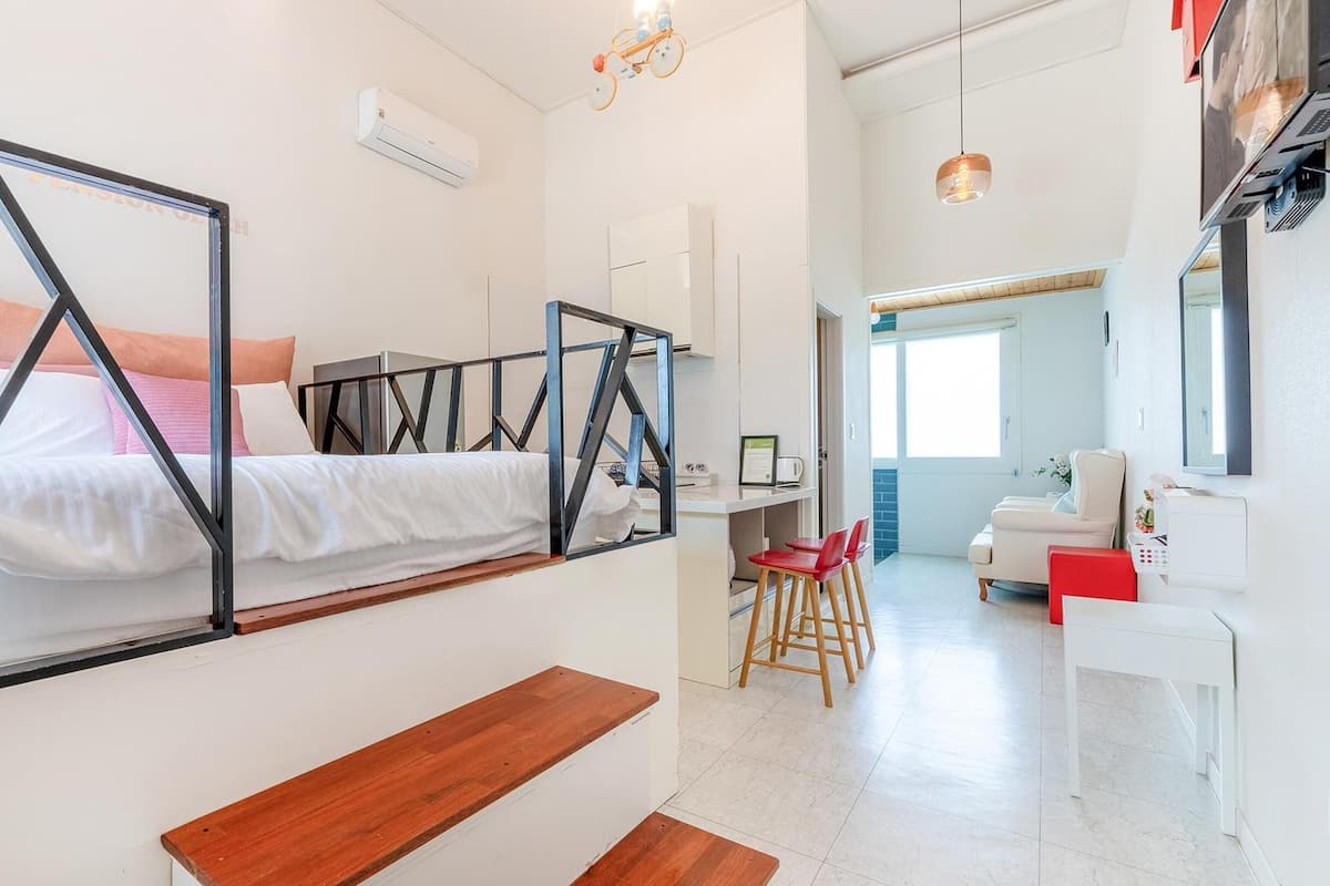 Ein modernes Hotelzimmer mit Bett, Schreibtisch und einer Sitzecke.