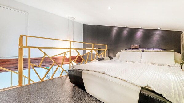 A modern bedroom with a bed, a headboard, and a unique geometric partition. - Gangneung Olraeendaol Spa Pension (Gangneung)