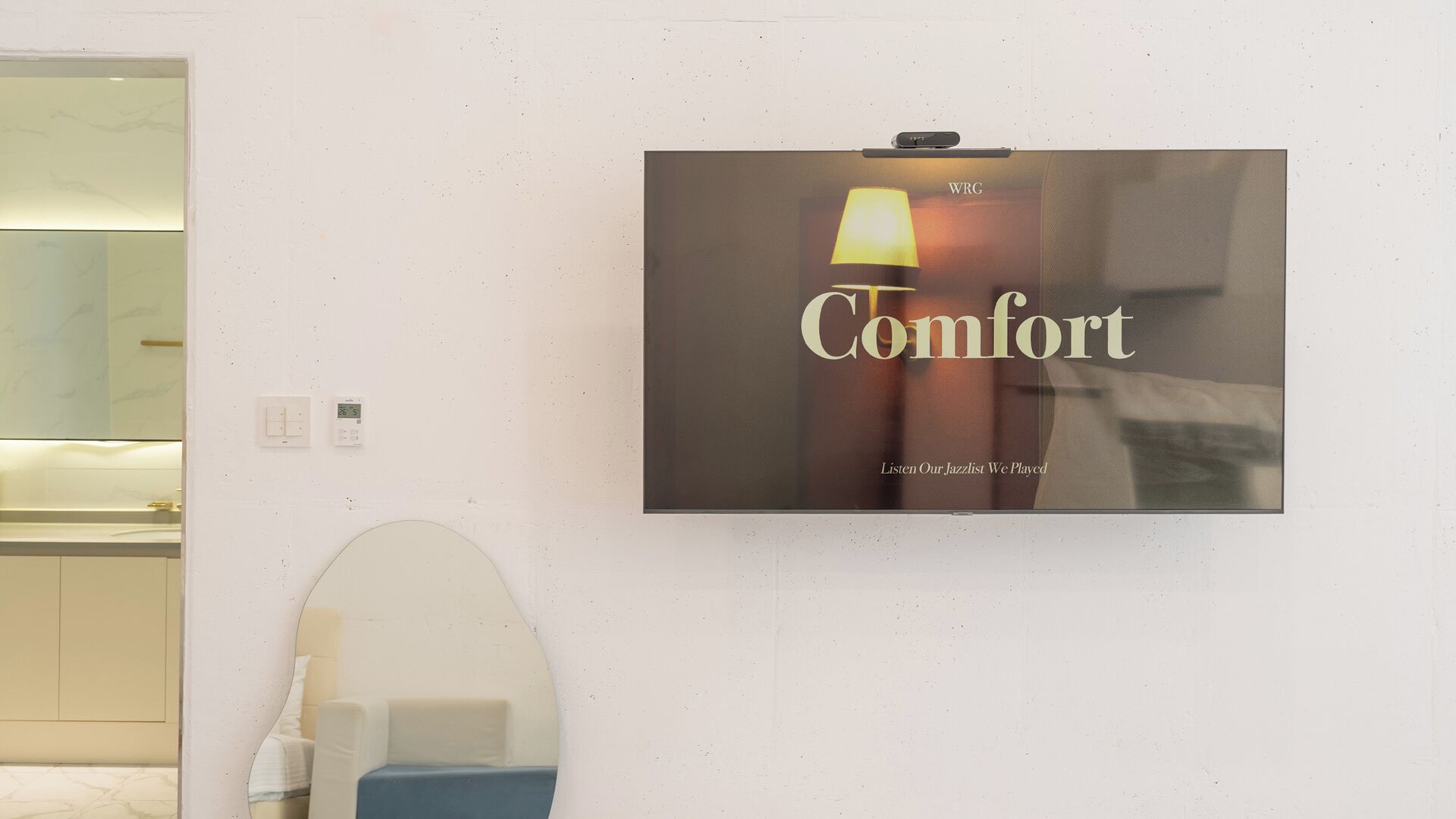 A framed poster on a wall with the word 'Comfort' and a lamp image.