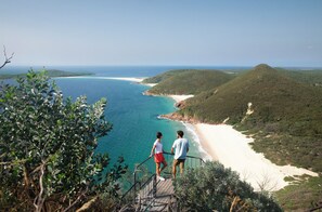 A coastal landscape with a beach and hills.