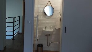 A bathroom with a white sink, mirror, and towel rack.