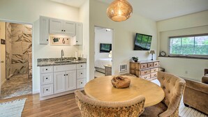 A modern kitchen with white cabinets, a granite countertop, and a hanging pendant light. - Rancho Santa Fe Casita - Gate Guarded Community! (Rancho Santa Fe)