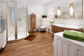 A modern bathroom with a glass shower enclosure, a toilet, a sink, and a vanity. - Family-Friendly Apartment "Fuchsbaude" with Wi-Fi (Allrode)