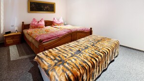 A bedroom with a bed, a nightstand, a lamp, and a painting on the wall.