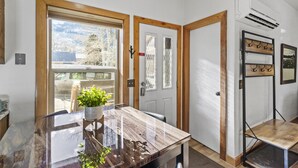 Une cuisine moderne avec une table en bois, une plante en pot et une vue sur l’extérieur.