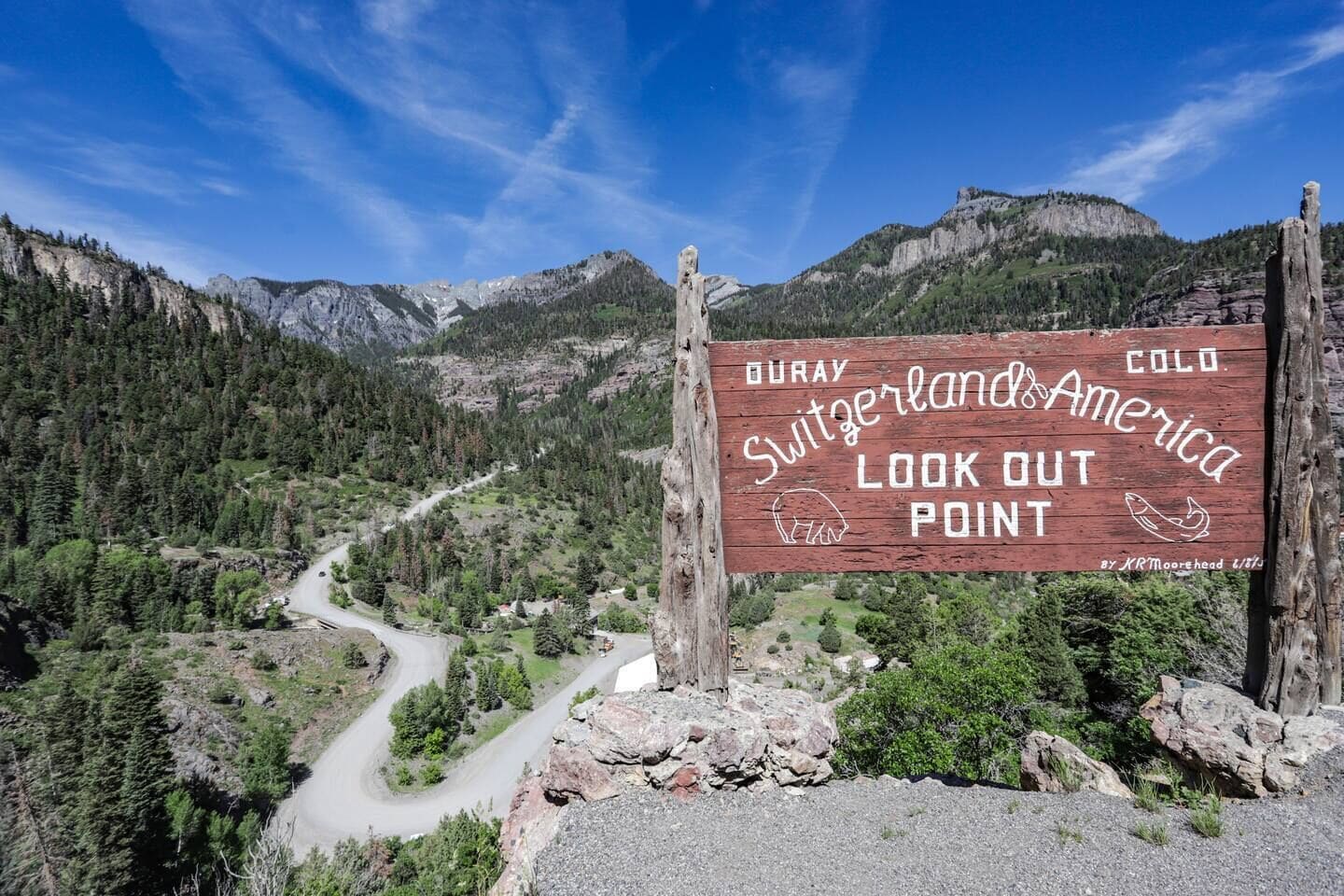 Un cartel que dice 'DURAY, SWITZERLAND & AMERICA LOOK OUT POINT' y un paisaje montañoso.