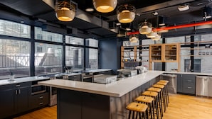 Una cocina moderna con una isla grande, taburetes de bar y ventanas amplias.