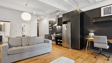 Une cuisine moderne avec un canapé gris, un plancher en bois et une table basse en marbre.