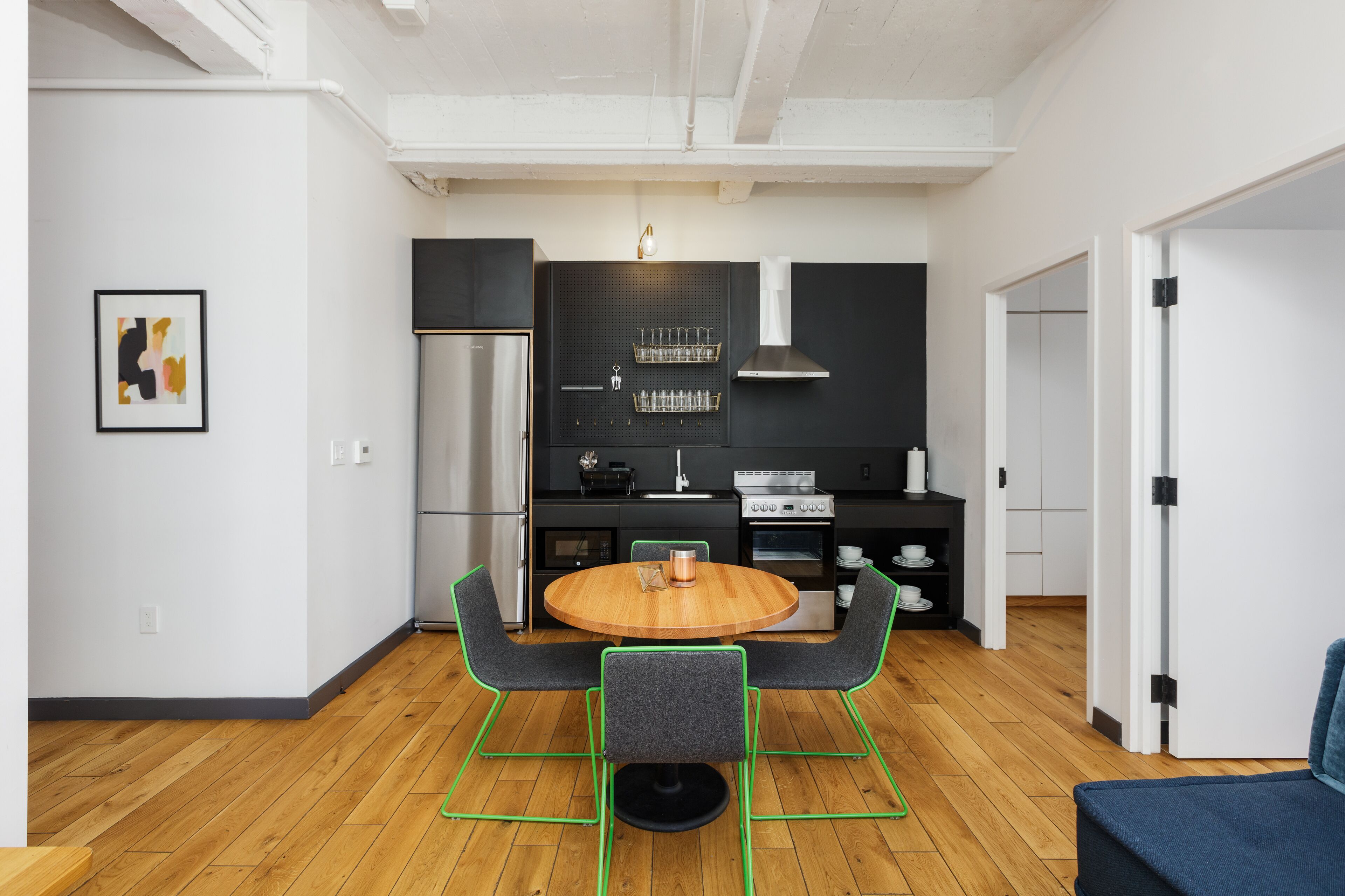 A modern kitchen with a round wooden table, two chairs, and a built-in oven.