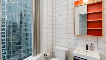 Een moderne badkamer met toilet, wastafel en spiegel.