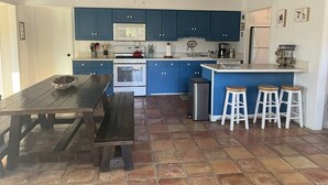 A kitchen with blue cabinets, a white stove, and a tiled floor.